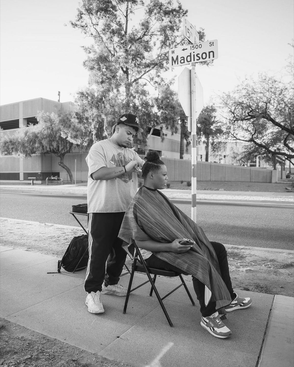 A volunteer giving a free haircut on a street corner