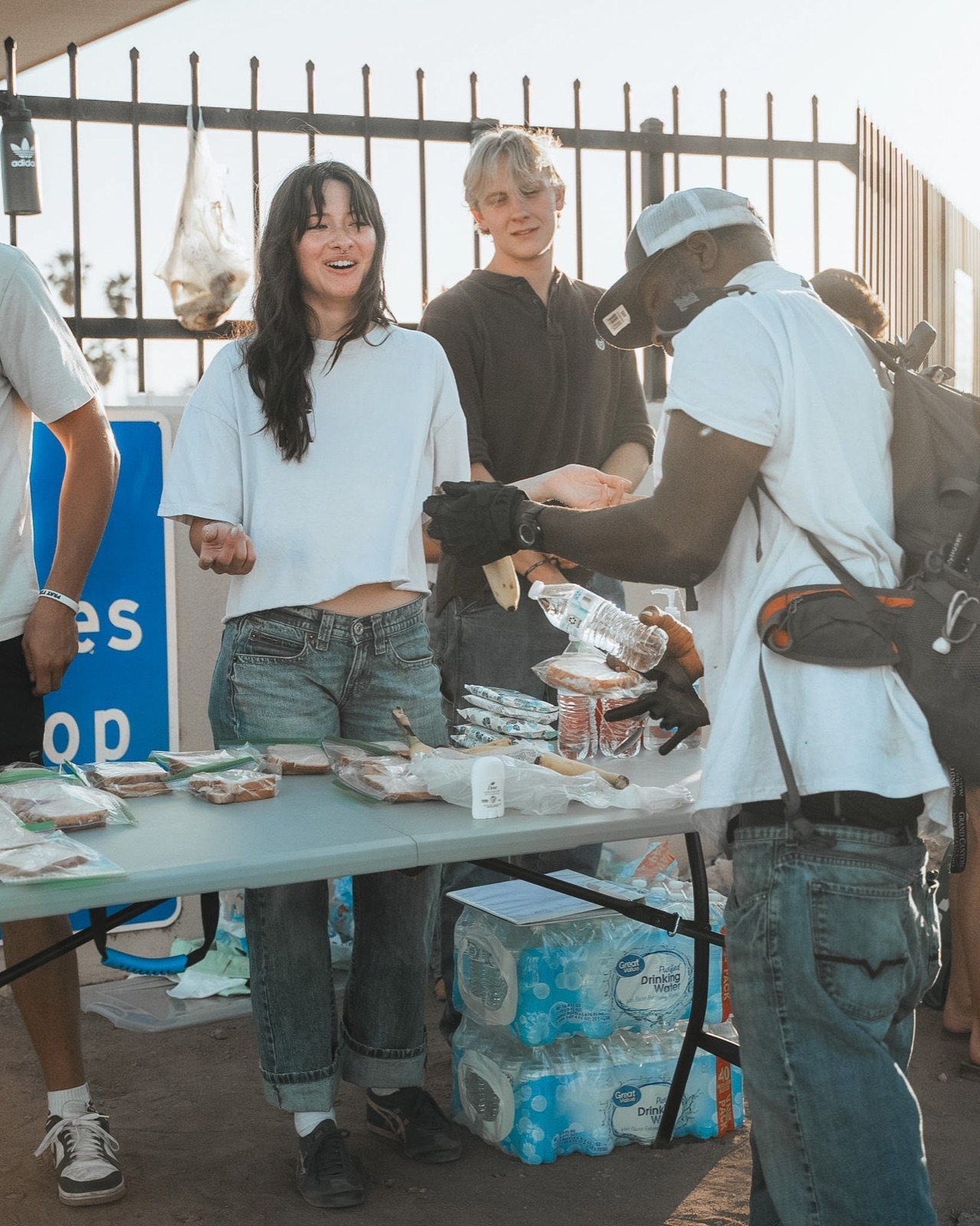 Volunteers handing out food and water from a table on the street