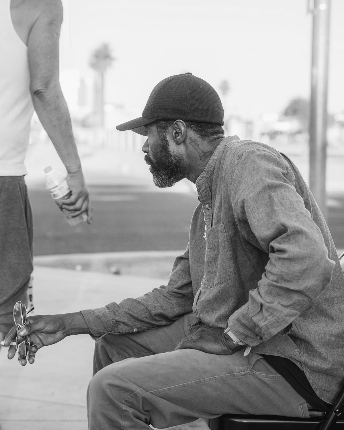 A man being handed a bottle of water and his glasses